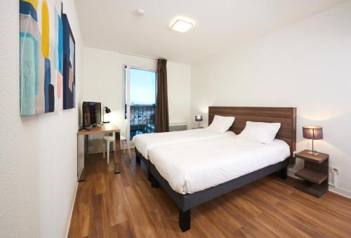 塔朗斯塔朗斯特内欧公寓式酒店的卧室设有一张白色大床和一扇窗户。