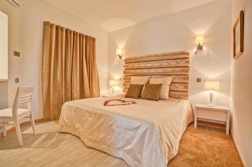 维拉摩拉Prado Villas的一间卧室配有一张大床和一把椅子