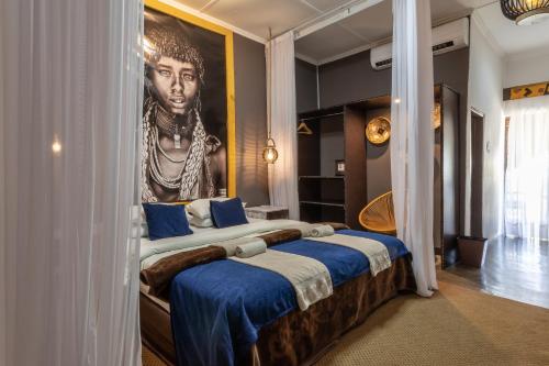 利文斯顿Ngoma Zanga Lodge的卧室配有一张大床,墙上挂有绘画作品