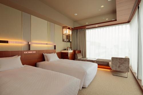 埼玉市Candeo Hotels Omiya的酒店客房设有两张床和窗户。