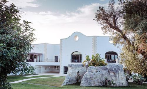 阿卡亚Acaya Golf Resort & Spa的前面有树木的白色建筑
