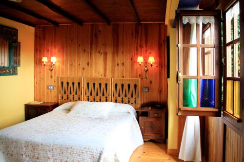 卢安科Casas Rurales Pradina I y II的卧室配有白色的床和窗户。