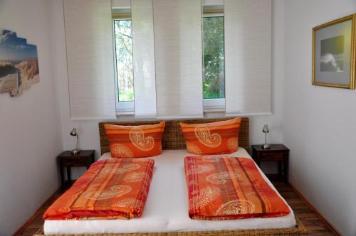 奥门豪斯特Ferienhaus Pension Sonnenblume的一间卧室设有两张床和两个窗户。