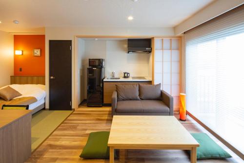 伊万里市Hotel Imari Aioibashi Bettei的带沙发和床的小客厅