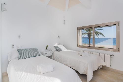波连萨港VILLA HOLLAND 11的一间卧室设有两张床和一个海滩窗口