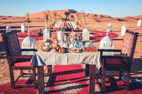 梅尔祖卡Luxury Desert Camp Amanar的一张桌子,上面有食物在沙漠里