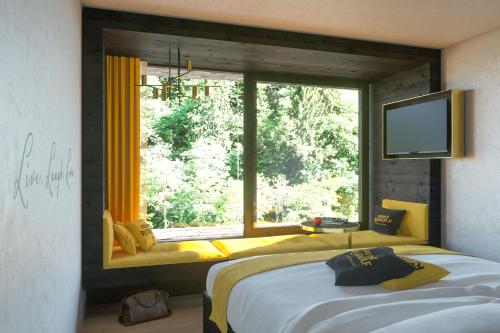 梅拉诺Prinz Rudolf Smart Hotel的一间卧室设有一张床和一个大窗户
