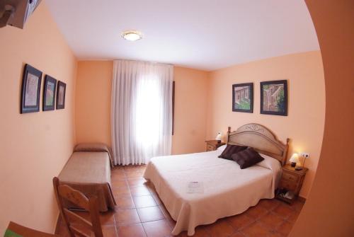 瓜尔迪奥拉-德贝尔加杜奈酒店的卧室配有白色的床和窗户。