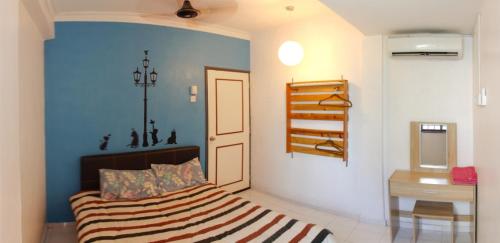 马六甲DT Homestay floor level 4的一间卧室配有一张蓝色墙壁的床
