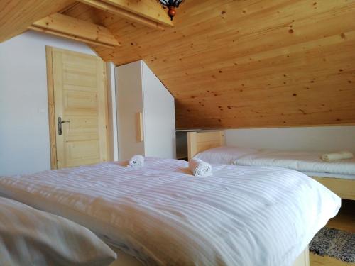 斯祖贝莱克Domček Michaela的一间卧室设有两张床和木制天花板