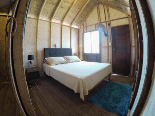 曼克拉Wild Rover Beach Mancora的卧室配有圆镜子内的床铺
