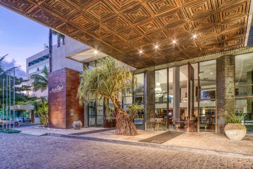 马塞约拉戈阿达安塔酒店的前面有棕榈树的建筑