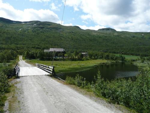 UvdalJønndalen Høyfjellseter的一条桥,一条路旁的河上
