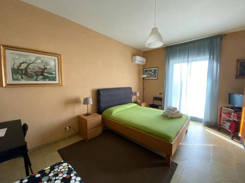 阿格里真托Terra Di Mare的一间卧室设有一张绿色的床和一个窗户。
