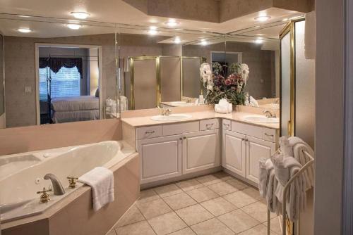 布兰森法语区度假酒店的大型浴室设有两个盥洗盆和浴缸。