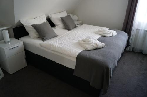 LotteLa Domus Premium Osnabrück Lotte的一间卧室配有带白色床单和枕头的床。