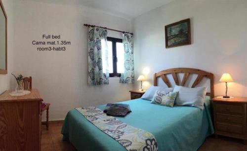 MalaCasa GABO Mala-Lanzarote Norte的一间卧室配有一张带蓝色棉被的床