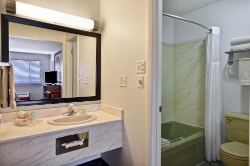摩押远征汽车旅馆的一间带水槽、镜子和淋浴的浴室