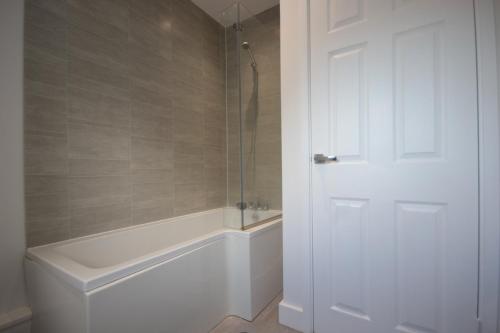 赫尔Studio 332的带淋浴和浴缸的浴室以及白色门。