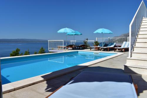 布雷拉Guest House Vineyard oaza的一座大楼内的游泳池,配有椅子和遮阳伞