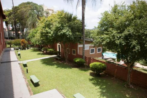 阿蒂巴亚阿蒂巴亚格兰德酒店的一座有长椅和树木的院子,毗邻一座建筑