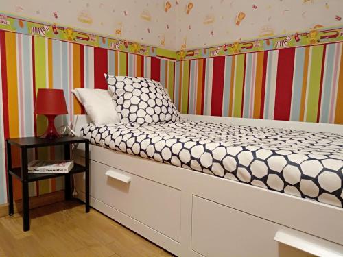 卡拉塔尤德Apartamento Ayub的一张小床,位于带条纹墙的房间里