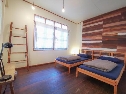 南奔匹克班旅舍的一间卧室设有两张床和木墙
