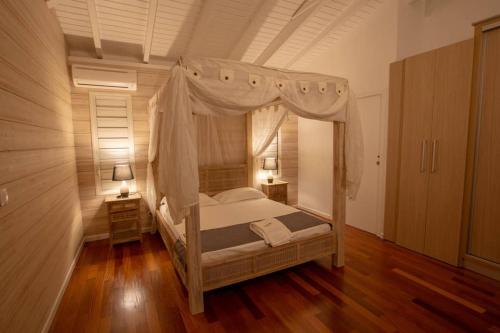 波尔兰特Sunset Lodge的一间卧室设有一张天蓬床和木地板