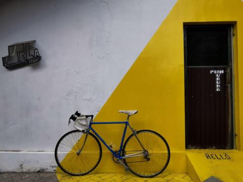 日惹Sela Stay的停在黄色和白色建筑旁边的自行车