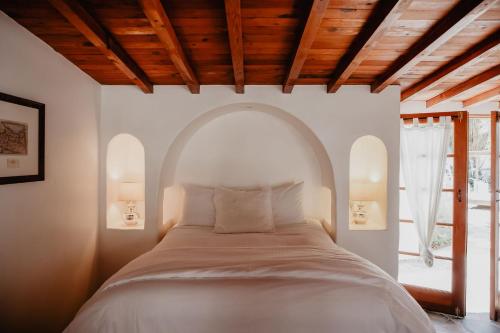棕榈泉考卡酒店的一间卧室设有一张大床和拱形窗户
