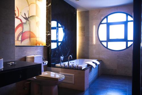 北芭堤雅Long Beach Garden Hotel & Pavilions的带浴缸、卫生间和窗户的浴室