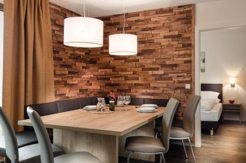 滨湖采尔AlpenParks Chalet & Apartment AreitXpress的一间带木桌和椅子的用餐室