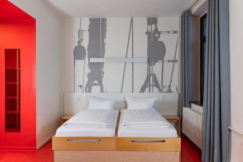 不来梅港布莱梅港哈维酒店的一间卧室设有一张床和红色的墙壁