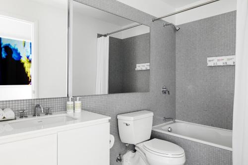 华盛顿 Liz by Black Swan - DC Executive Flat的浴室配有卫生间、盥洗盆和浴缸。