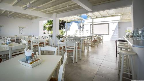 德里奥斯艾维酒店的一间设有白色桌子和白色椅子的餐厅