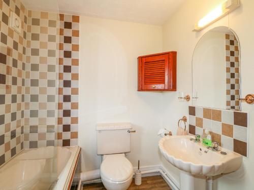 OversealBramble Grange的浴室配有盥洗盆、卫生间和浴缸。