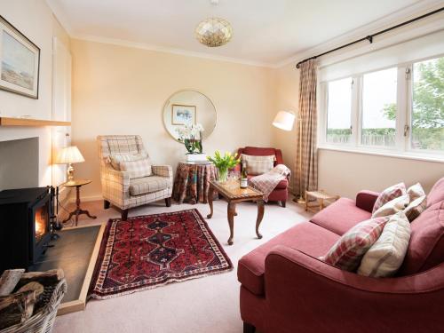 BowsdenBarmoor Ridge的客厅设有红色的沙发和壁炉