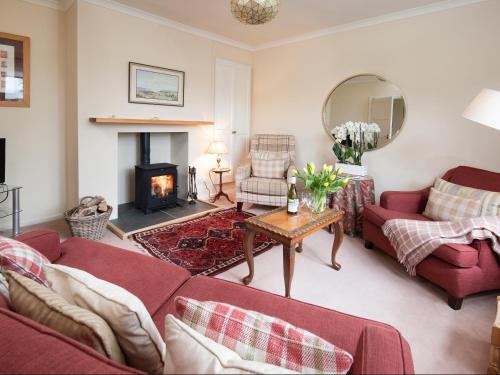BowsdenBarmoor Ridge的客厅设有2张红色的沙发和壁炉