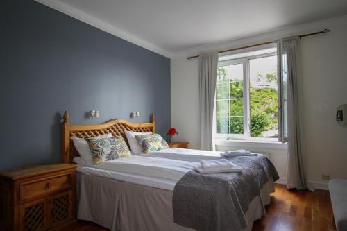 特韦德斯特兰Tvedestrand Fjordhotell - Unike Hoteller的一间卧室设有一张大床和一个窗户。