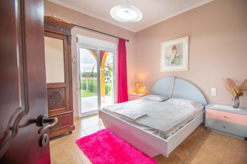 伊奥斯克里克斯Loukas Farm House的一间卧室配有一张床,一扇门配有粉红色地毯