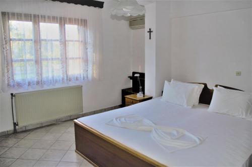 斯卡拉索提罗斯Vranas Property的卧室配有一张白色大床,上面有毛巾
