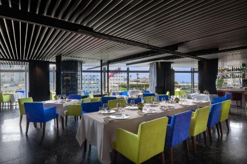 香港马哥孛罗香港酒店的用餐室配有白色的桌子和蓝色的椅子