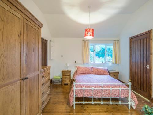 彻奇斯特雷顿Woodpeckers Cottage的一间卧室配有一张床、一个梳妆台和一扇窗户。