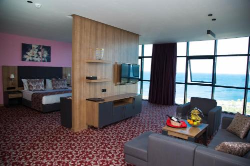 巴统Euphoria Batumi Convention & Casino Hotel的酒店客房设有床和客厅。