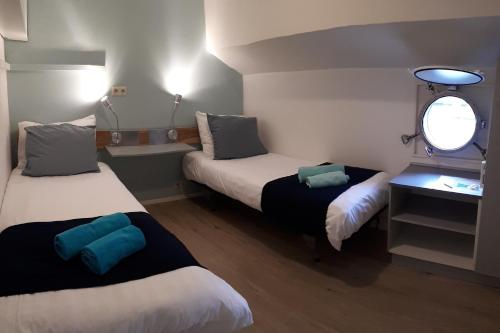 鹿特丹Rooms on Water的小房间设有两张床和窗户