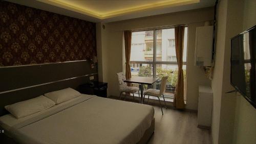 艾登Aydın Kent Suit的一间卧室配有一张床、一张桌子和一个窗户。