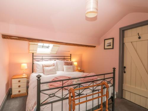 斯卡伯勒Honey Bee Cottage的一间卧室配有一张粉红色墙壁的床