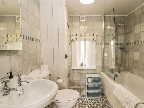 斯卡伯勒Honey Bee Cottage的浴室配有盥洗盆、卫生间和浴缸。