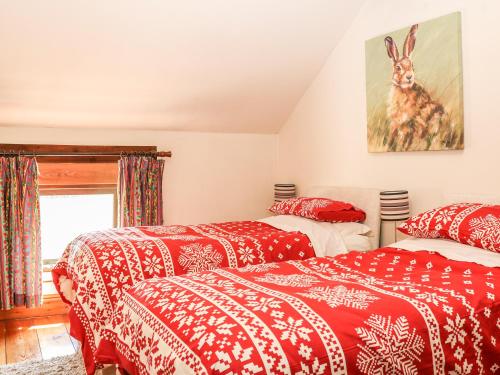 巴克斯顿The Parlour的配有红色和白色毯子的客房内的两张床