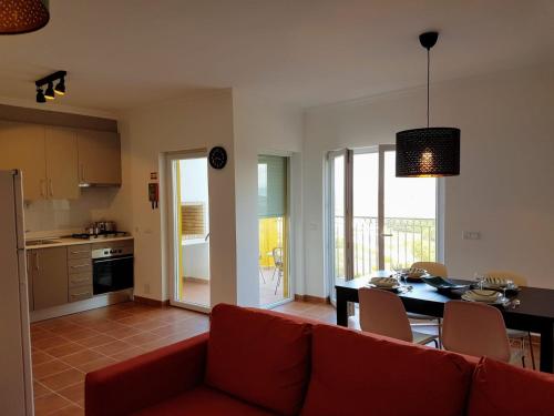 阿尔热祖尔Cozy apartment in Algarve West Coast - Aljezur (2 min da Praia Monte Clérigo)的客厅配有红色的沙发和桌子